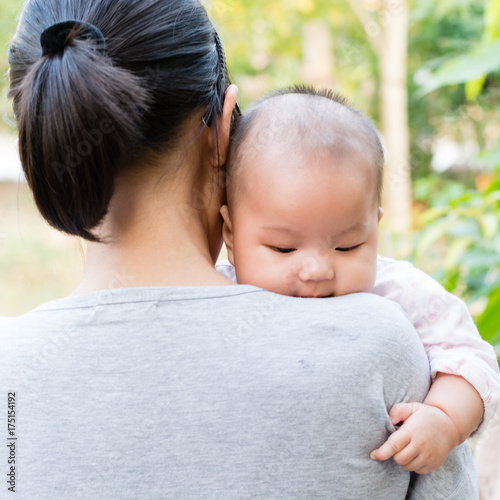 Mother holding adorable baby daughter in her arms