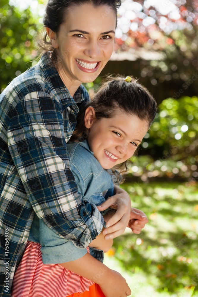 Cheerful mother embracing daughter in yard Cheerful mother embracing daughter in yard