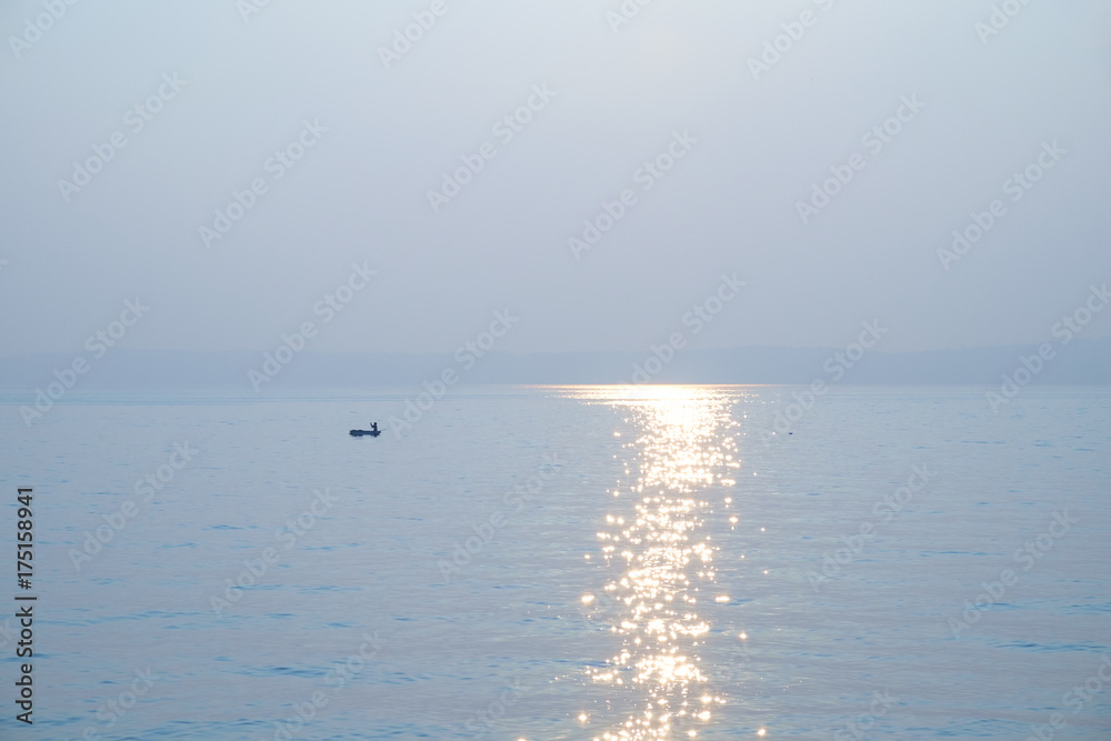 Fishing boat and sun streak on water