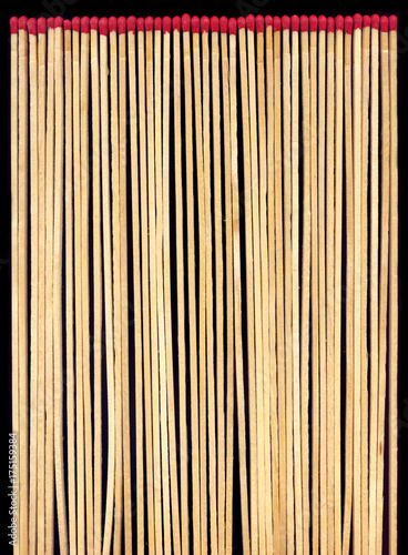 Long wooden matches on a black background