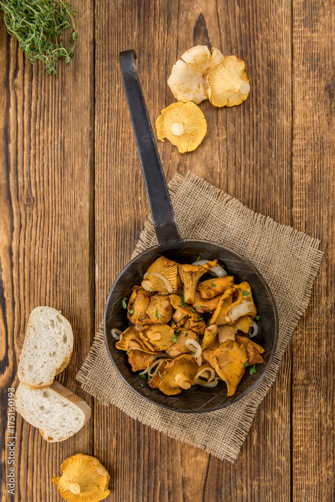 Fried Chanterelles on wooden background; selective focus Fried Chanterelles on wooden background; selective focus