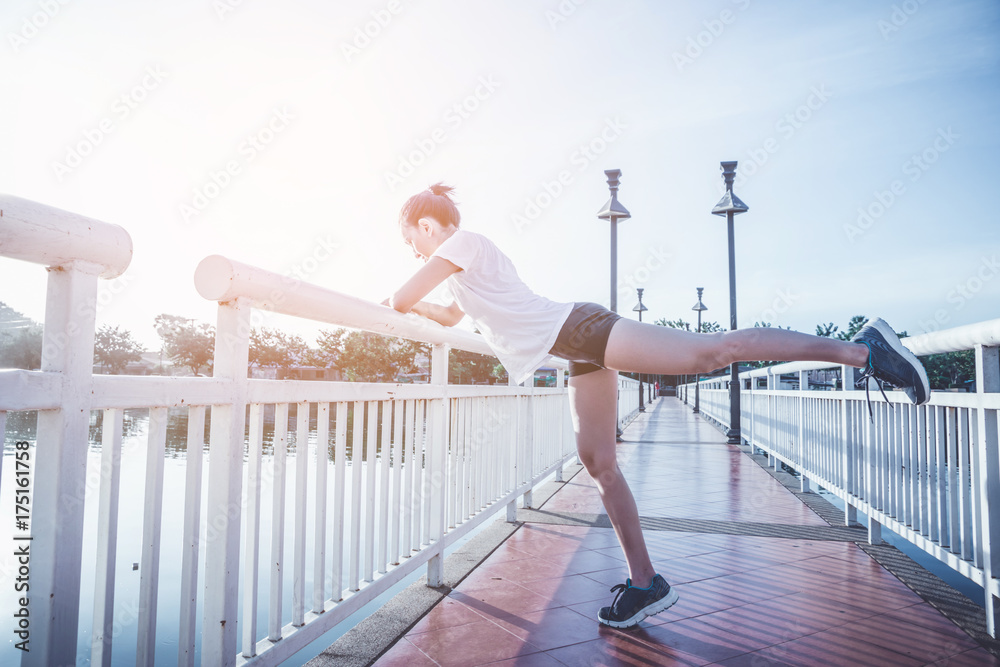 Healthy woman doing exercises and warm up before running and jogging on bridge at morning Healthy woman doing exercises and warm up before running and jogging on bridge at morning