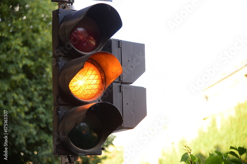 Yellow light of traffic lights in summer city