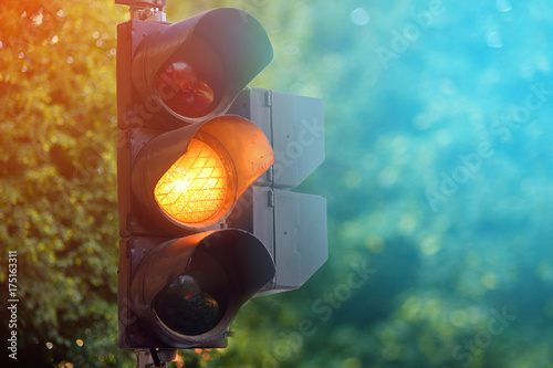 Fotografie, Obraz Yellow light of traffic lights in summer city