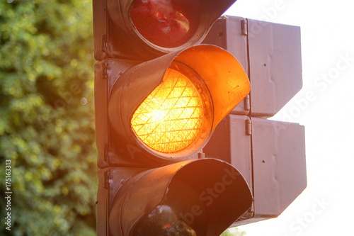 Yellow light of traffic lights in summer city