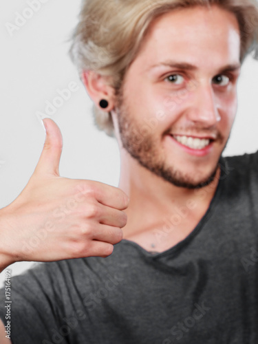 Content young man giving thumb up