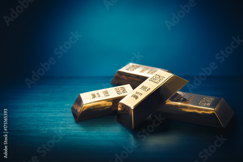 Pile of gold bars or ingots on a dark background - 3D illustration photo