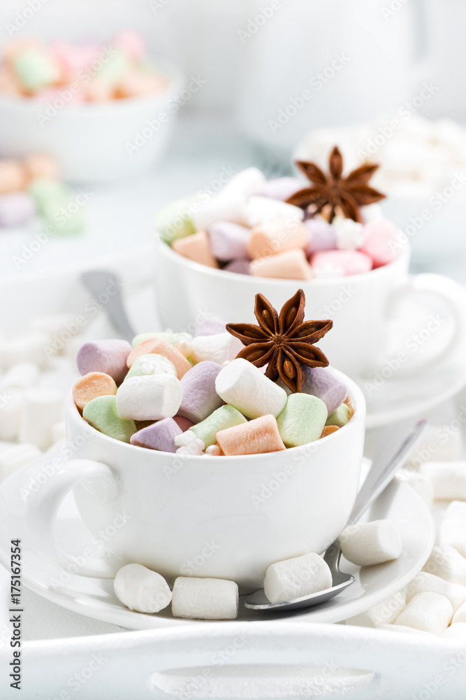 cocoa with colorful marshmallows and spices in cups, vertical cocoa with colorful marshmallows and spices in cups, vertical