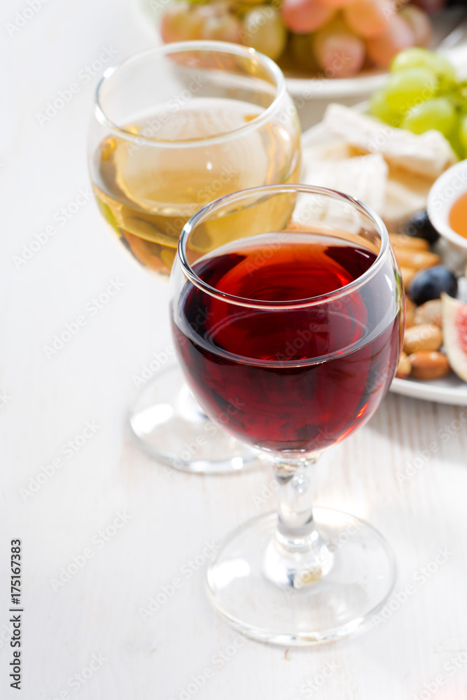 glasses with wine and snacks on white table, vertical glasses with wine and snacks on white table, vertical