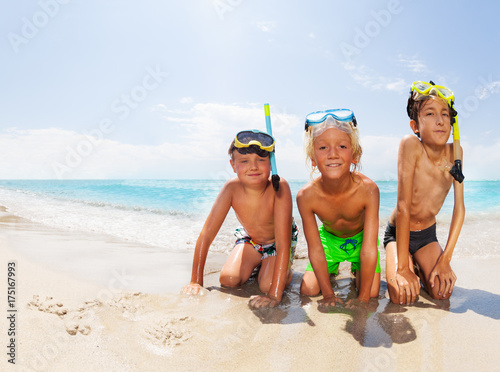Boys on the sea beach before diving in scuba masks