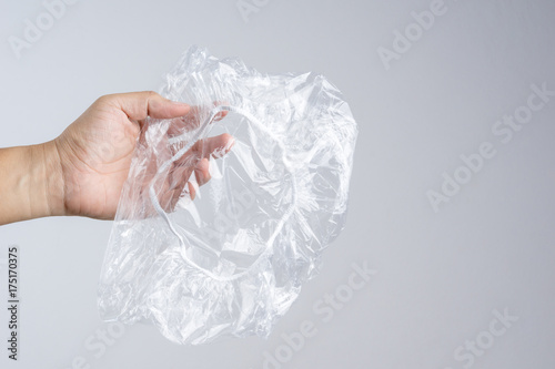 Hand holding disposable transparent plastic shower cap