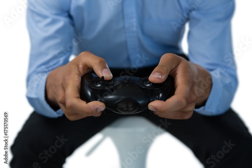 Mid section of creative businessman playing video game