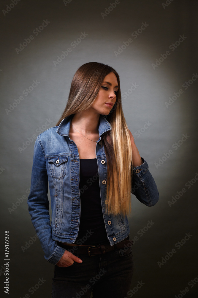 a young very beautiful woman in a black T-shirt denim jacket and pants  turning to