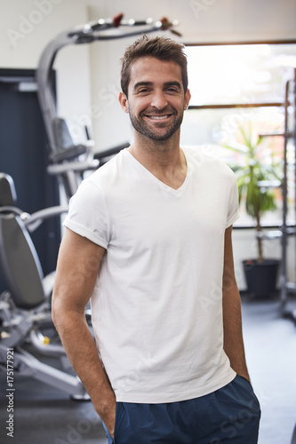 Happy dude in gym in white t-shirt, portrait