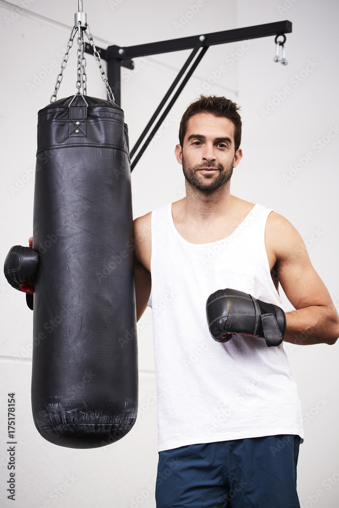 Boxing guy posing next to punch bag, portrait