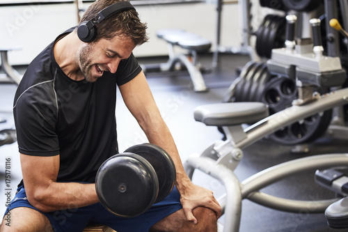 Dude lifting weight in gym, looking down © sanneberg