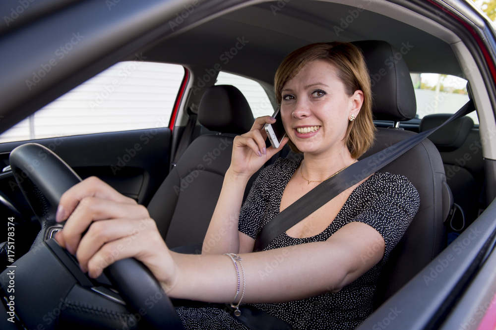 woman talking happy on mobile phone while holding car steering wheel driving distracted