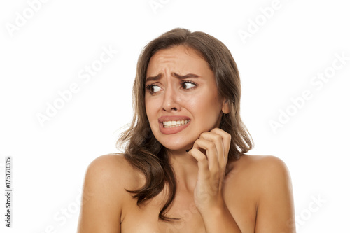 Portrait of beautiful young scared woman on white background