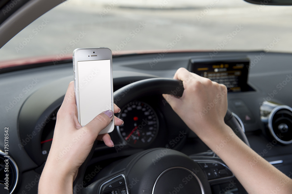 hand of woman holding steering wheel and mobile phone driving car while texting distracted in risk