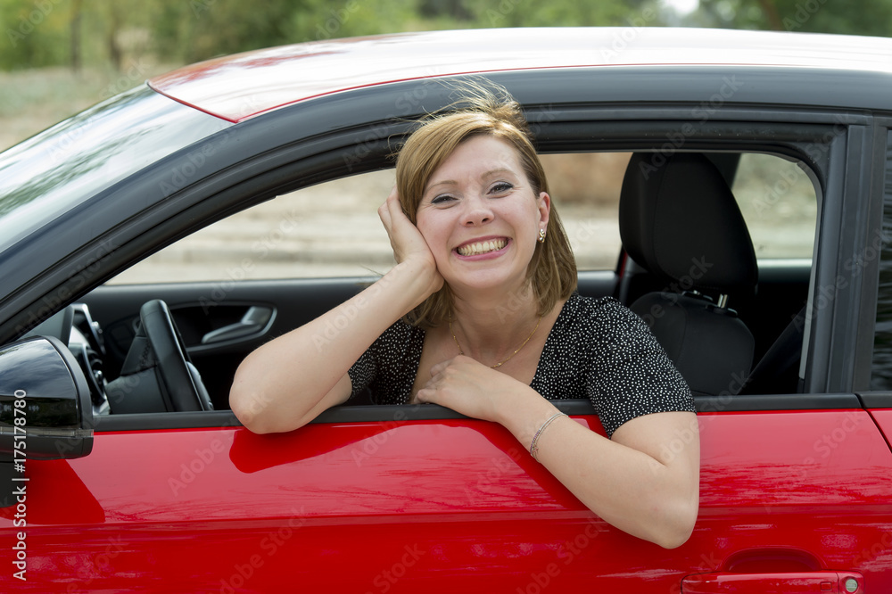 happy attractive woman sitting at driver seat smiling cheerful and proud waving hello from new car