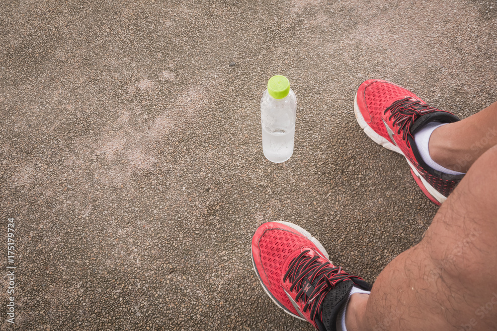 Red shoes running with drinking water on concrete floor.