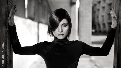 Fashion art portrait of elegant girl in geometric. Black and white photo of stylish young woman in cityscape . Stunning girl .