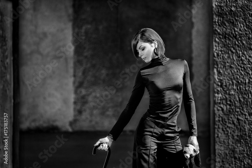 Fashion art portrait of elegant girl in geometric. Black and white photo of stylish young woman in cityscape