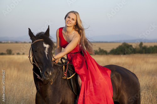 Blonde with smile sitting on horse