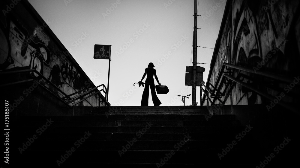 Fototapeta premium Fashion art portrait of elegant girl in geometric. Black and white photo of stylish young woman in cityscape