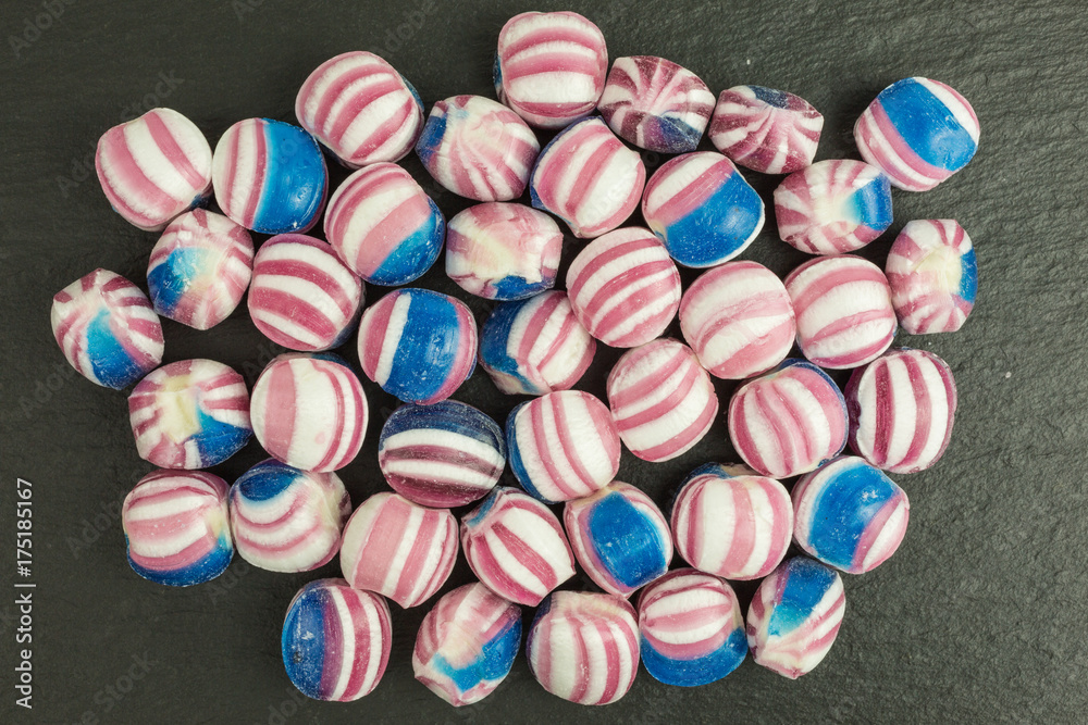 Fototapeta premium candy in blue, red and white on slate plate