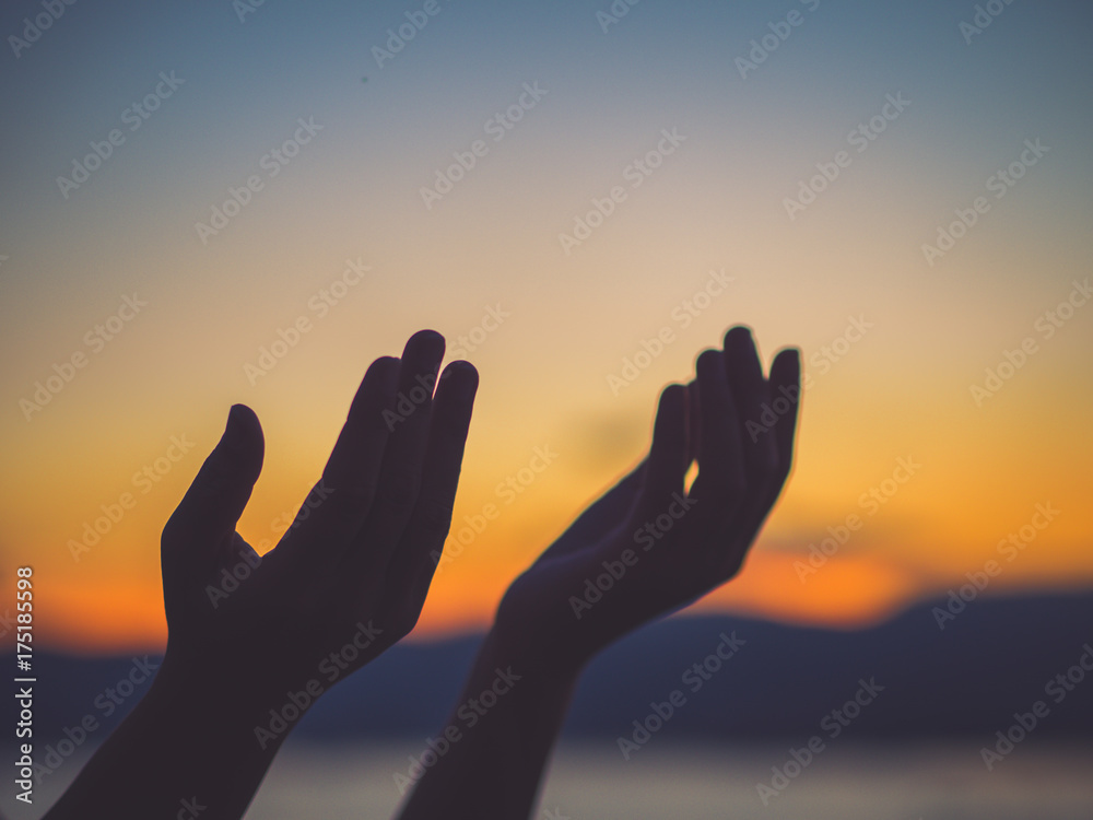 Closeup woman hands praying for blessing from god during  sunset background. Hope concept.