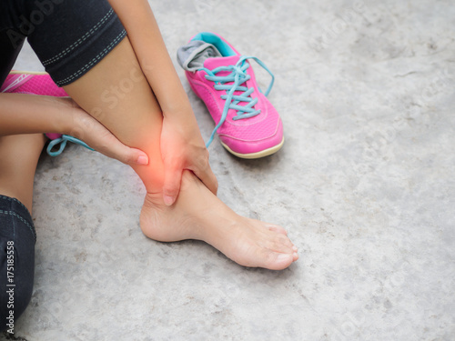 Woman suffering from an ankle injury while exercising. Running sport injury concept.