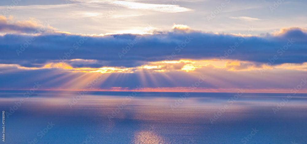 Beautiful scenery with clouds and sunbeams in blue and orange colors