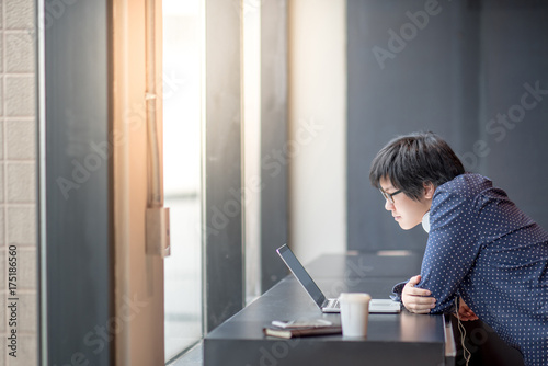 Young Asian businessman working with his laptop computer in office. new generation entrepreneur and urban lifestyle concepts