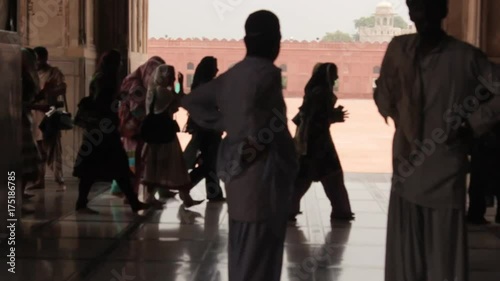 People In Black Light Walking Near Mosque Entrance - Static 