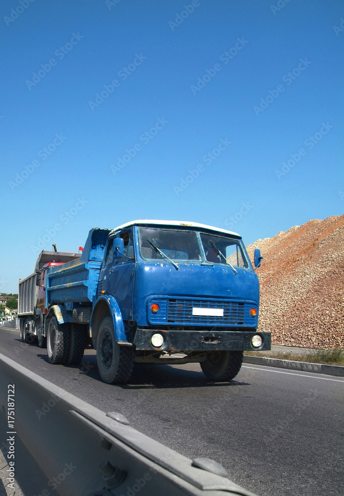 Old truck transports the bulk cargo on the highway. Front view. Wide angle