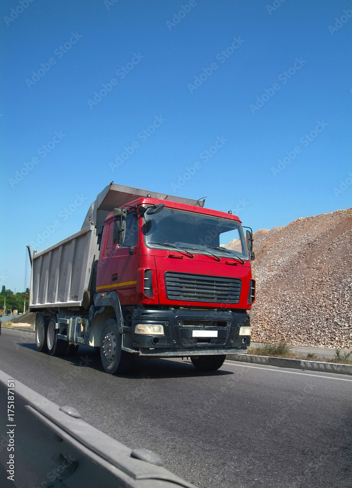 Modern self-unloading Truck transports the bulk cargo on the highway. Front view. Wide angle