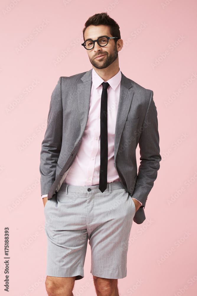 Suit with shorts on handsome guy in pink studio, portrait Suit with shorts on handsome guy in pink studio, portrait