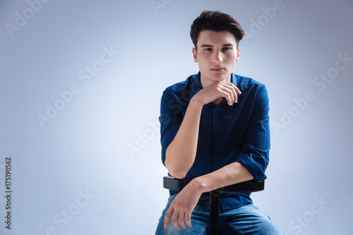 Thoughtful male person leaning on chair