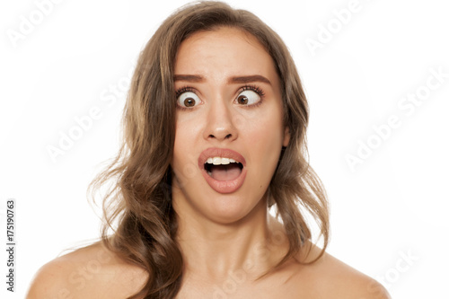 Portrait of beautiful young woman making funny faces on white background