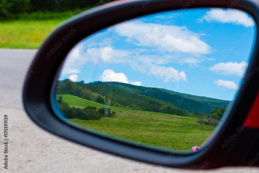 The view to the beautiful land through mirror of car