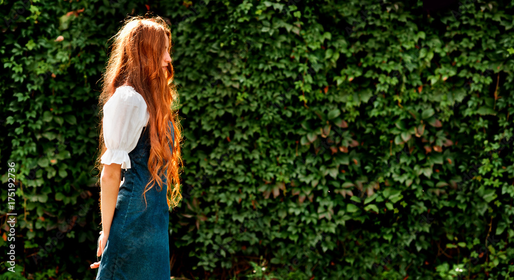 autumn portrait of redhead girl with wild grape wall