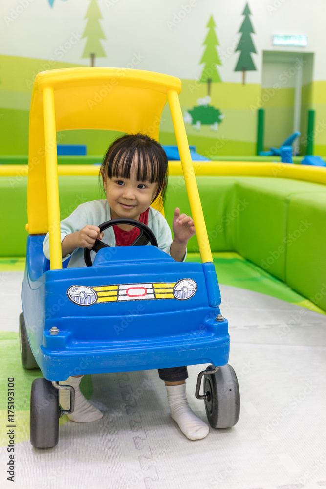 Asian Chinese little girl driving toy car Asian Chinese little girl driving toy car