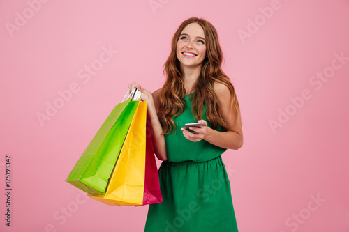 Portrait of a pretty woman in dress holding mobile phone