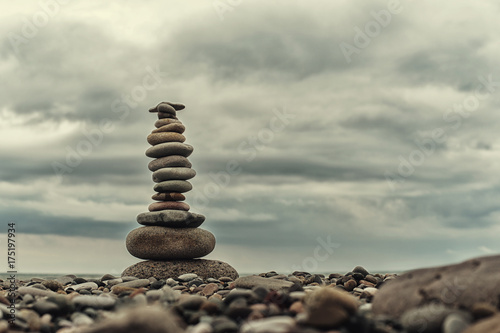 Stone cairn on green blurry background   pebbles and stones