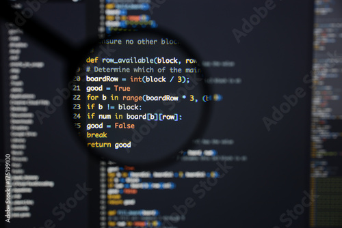 Real Python code developing screen. Programing workflow abstract algorithm concept. Lines of Python code visible under magnifying lens.