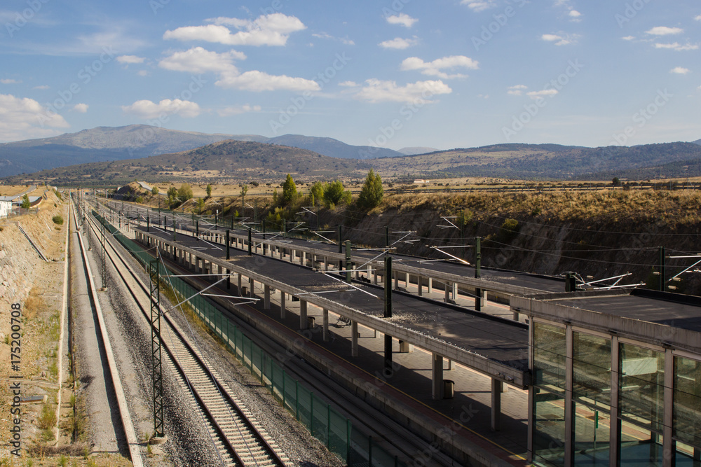 Outdoor railway station with mountains and blue sky background