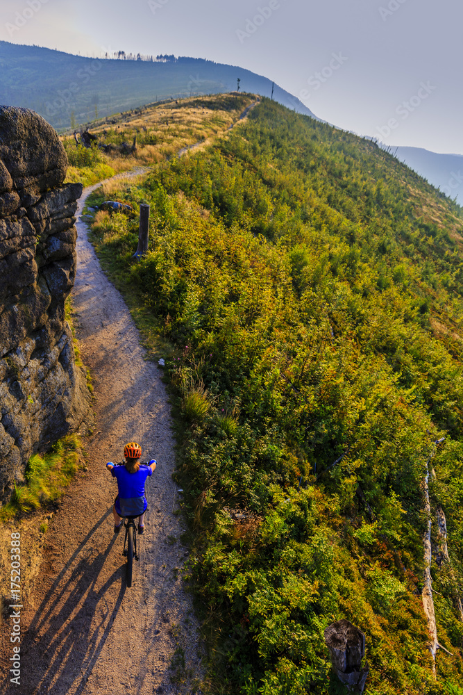Obraz premium Cycling, mountain bikeing woman on cycle trail in autumn forest. Mountain biking in autumn landscape forest. Woman cycling MTB flow uphill trail.