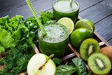 Green smoothie with vegetables, fruits and herbs. Healthy smoothie with apple, spinach, lime, kiwi and herbs. Healthy drink and eating concept. Closeup