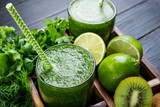Green smoothie with vegetables, fruits and herbs. Healthy smoothie with spinach, lime, kiwi and herbs. Healthy drink and eating concept. Closeup